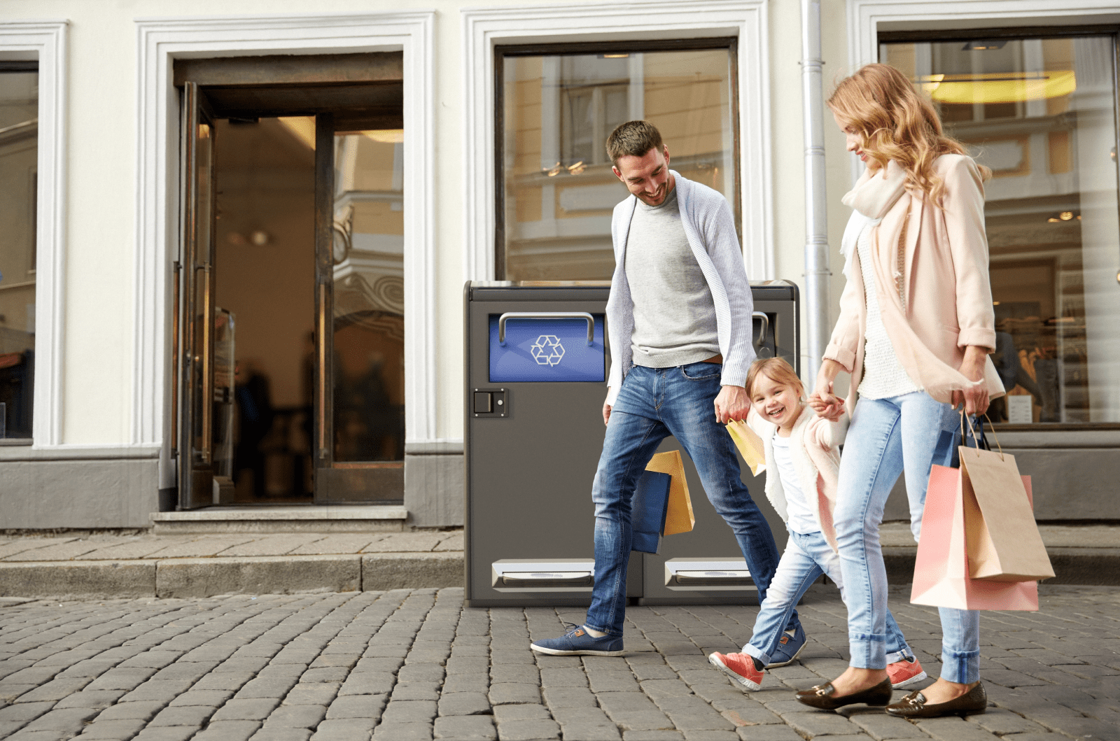 bigbelly recycling bin on public street with family walking by