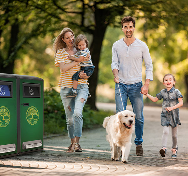 bigbelly recycling and trash bin in a public park with happy family walking by