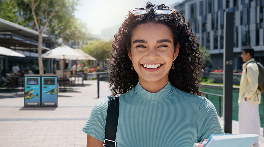 girl at university in front of bigbelly bins